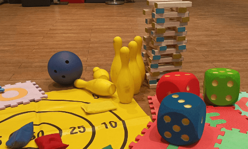 Verschiedene Kinderspiele auf dem Boden verteilt.