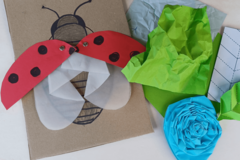Aus Papier gefaltete Rose und Marienkäfer