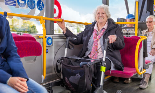 Seniorin mit Rollator fährt Bus