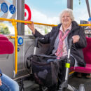 Seniorin mit Rollator fährt Bus