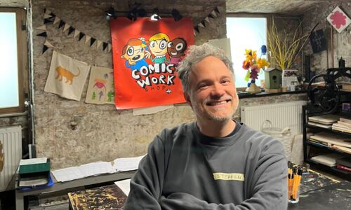 Mann (Steffen Hand) steht in einer Werkstatt und lächelt in die Kamera.