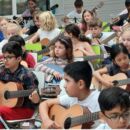Kinder spielen Gitarre.
