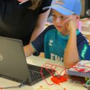 Junge sitzt vor einem Laptop und Makey Makey