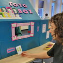 Person sitzt vor einer DIY-Fotobox und wird porträtiert