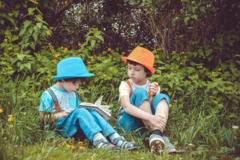 zwei Kinder lesen im Park