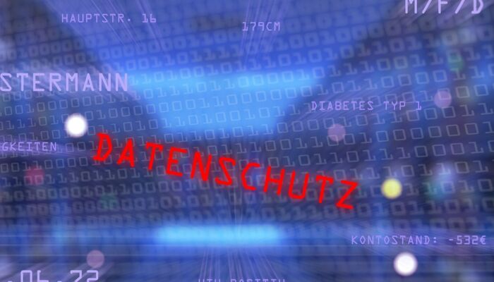 Das Wort Datenschutz in roter Schrift vor vielen Buchstaben und Zahlen auf blauem Hintergrund
