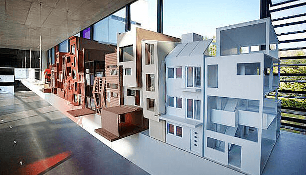 Architekturentwürfe von Studierenden sind in einem Ausstellungsraum zu sehen.