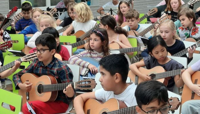 Kinder spielen Gitarre.