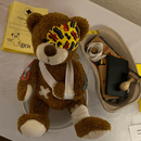 Ein Teddybär liegt bandagiert und mit Pflastern an Kopf und Bauch auf einem Behandlungstisch.