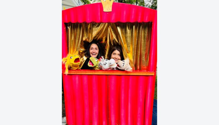 Zwei Personen, die ein Puppentheater vorspielen