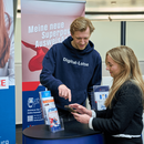 Ein Mann unterstützt eine Frau mir dem digitalen Service Angebot von Hamburg.