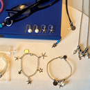 Diverse selbstgemachte Schmuckaccessoires, darunter Ohrringe, Halsketten und Armkettchen.