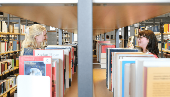 Zwei Personen stöbern Bücher in der Zentralbibliothek