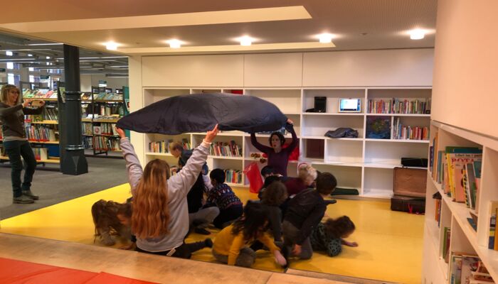 Personen und Kinder spielen in der Kinderbibliothek
