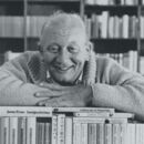 Schwarz-Weiß-Bild von James Krüss auf einem Stapel Bücher.