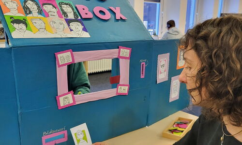 Person sitzt vor einer DIY-Fotobox und wird porträtiert