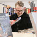 Mann stöbert in Bücherflohmarkt