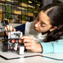 Schülerin bedient einen Roboter