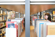 Zwei Personen stöbern Bücher in der Zentralbibliothek