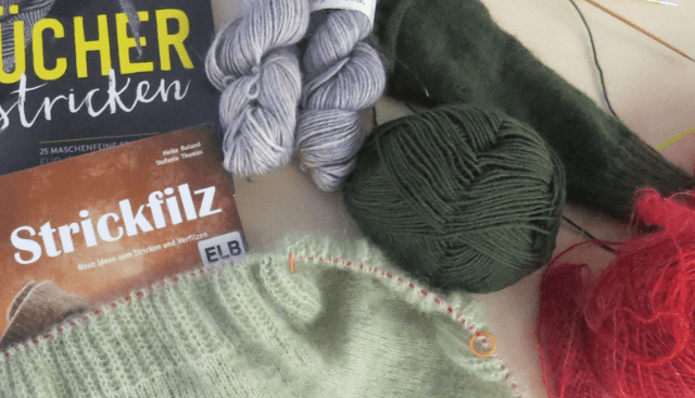 Strickwolle, Stricknadeln und zwei Bücher über Stricken