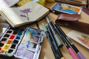 Aquarell-Palette, Notizbuch mit Blumenzeichnung und Stifte