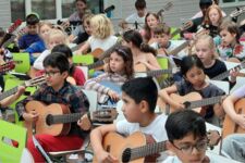 Kinder spielen Gitarre.