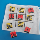 Tic-Tac-Toe-Spiel aus Holzblöcken, die als Bienen und Marienkäfer gestaltet sind.