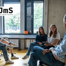 Eine Gruppe sitz im Stuhlkreis und unterhält sich.