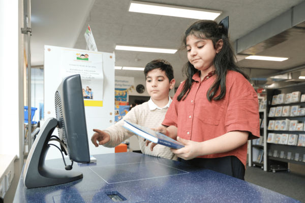 Kinder leihen ein Buch aus