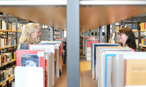 Zwei Personen stöbern Bücher in der Zentralbibliothek