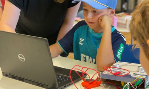 Junge sitzt vor einem Laptop und Makey Makey