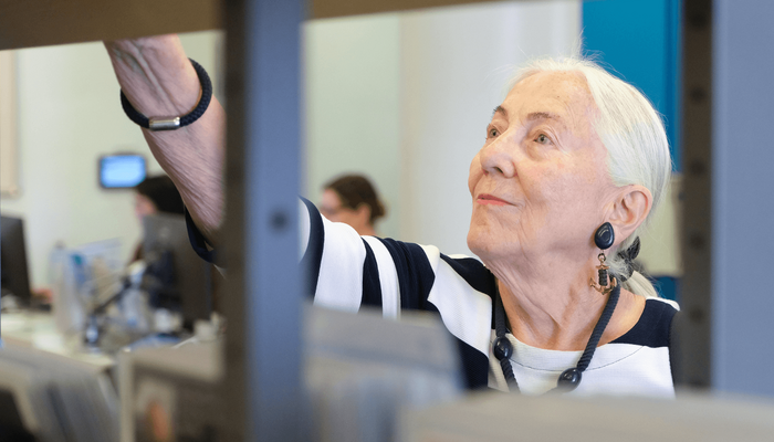 ältere Dame stöbert in der Bücherhalle