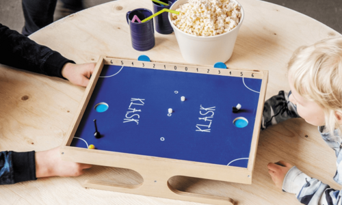Zwei Kinder spielen das Geschicklichkeitsspiel "KLASK".