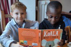 zwei Kinder lesen am Tisch