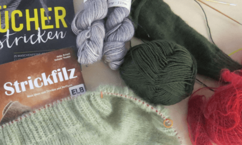 Strickwolle, Stricknadeln und zwei Bücher über Stricken