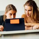 Zwei Jugendliche recherchieren am Bildschirm