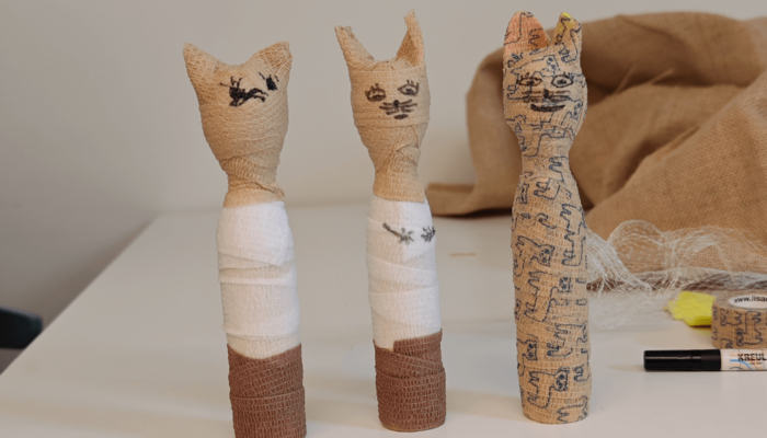 Drei gebastelte Katzen-Mumien aus Klebestreifen