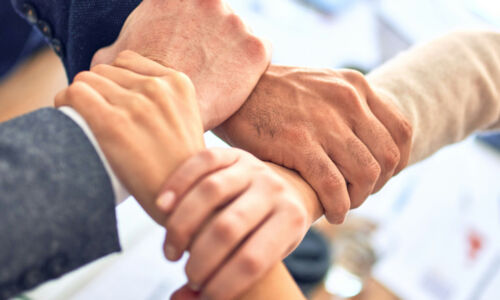 Vier Hände, die sich umfassen