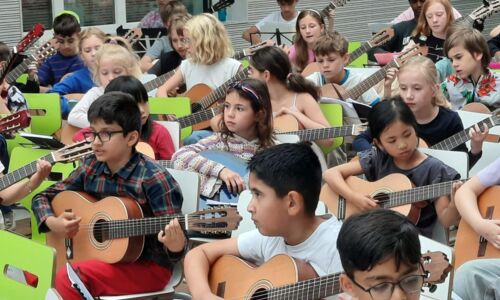 Kinder spielen Gitarre.