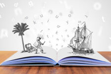 Buch auf Tisch mit visuellen Buchstaben und Illustrationen