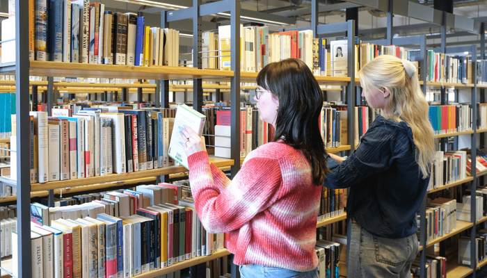 Zwei Personen stöbern Bücher in der Zentralbibliothek