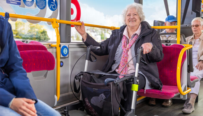 Seniorin mit Rollator fährt Bus