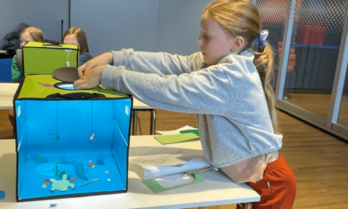 Ein Mädchen baselt ein Aquarium aus verschiedensten Materialien.