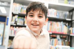 fröhlicher Junge in der Bücherhalle