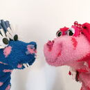 Ein blaues und ein rosa Monster, die aus Socken gebastelt sind.
