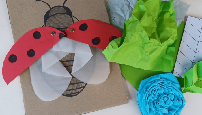Aus Papier gefaltete Rose und Marienkäfer