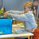Ein Mädchen baselt ein Aquarium aus verschiedensten Materialien.