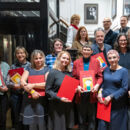 buntes Gruppenfoto mit Menschen, die stolz ihren Preis zeigen