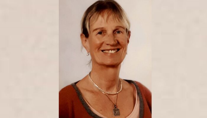 Frau im roten Oberteil vor einem neutralem Hintergrund (Silke Maddey).