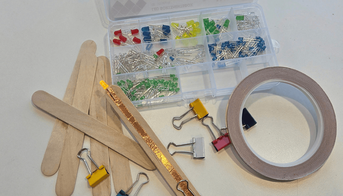 Klammern, Holzstäbe, Klebeband und kleine Lampen zum Basteln